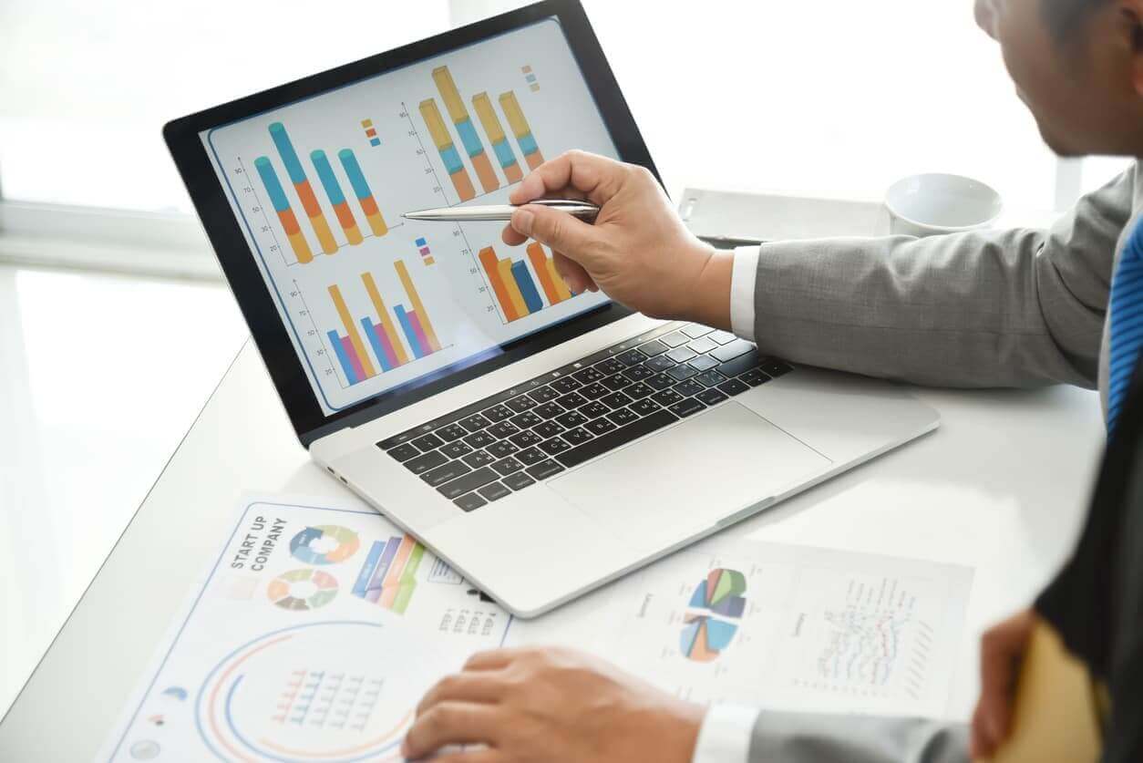 Businessman hand using laptop to look at graphs and statistics