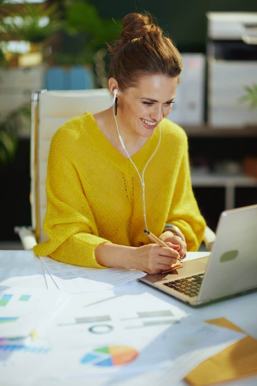 Smiling business owner woman in green office talking video call stock photo